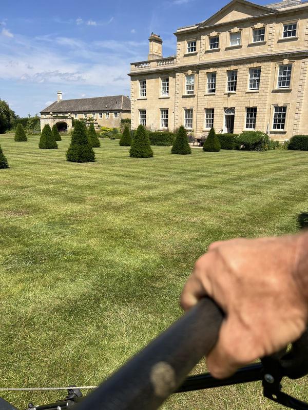 Mowing stripes into the lawn in front of a Georgian house